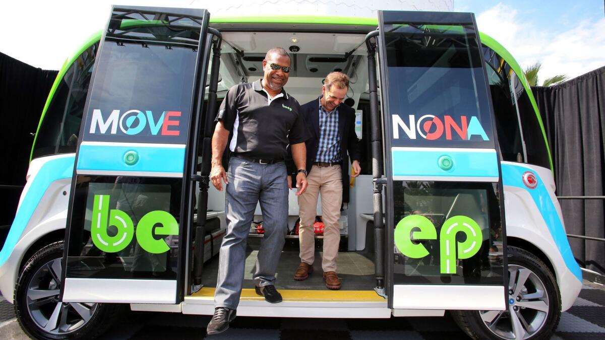 Beep co-Founder Mark Reid, left, and Tavistock President James Zboril step off the driverless shuttle, expected to be Central Florida's first autonomous public transportation service.