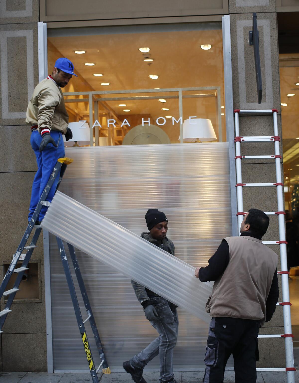 Workers set up protection over shop windows Dec. 7 on the Champs-Elysees in Paris.