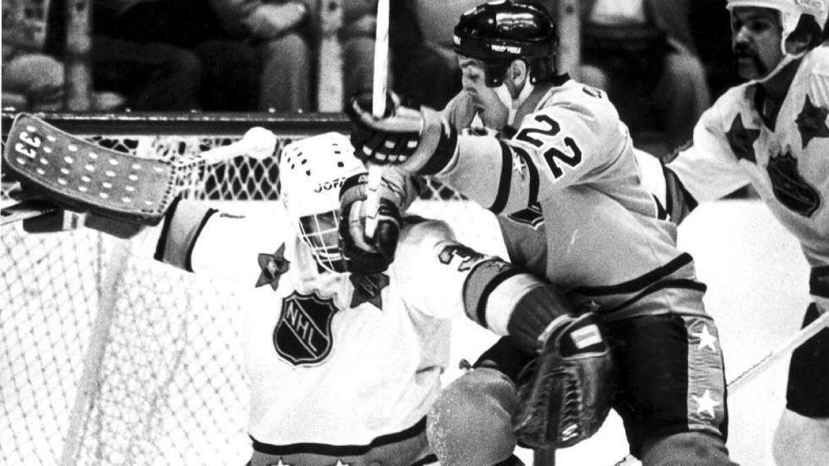 Prince of Wales conference goaltender Don Beaupre tries to fend off Dave Williams during the 1981 NHL All–Star game in Los Angeles.