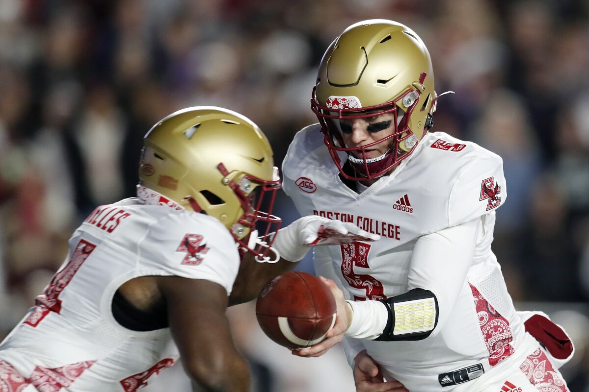 Boston College quarterback Phil Jurkovec (5) hands off to running back Pat Garwo III during the first half of the team's NCAA college football game against Virginia Tech, Friday, Nov. 5, 2021, in Boston. (AP Photo/Michael Dwyer)