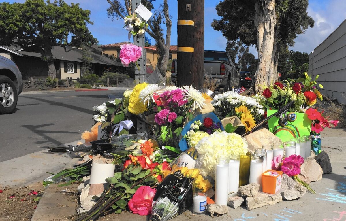 A roadside memorial is set up at the corner of 15th Street and Michael Place in Newport Beach in honor of an 8-year-old Newport Heights Elementary School student who was struck and killed by a trash truck at the intersection Wednesday afternoon.