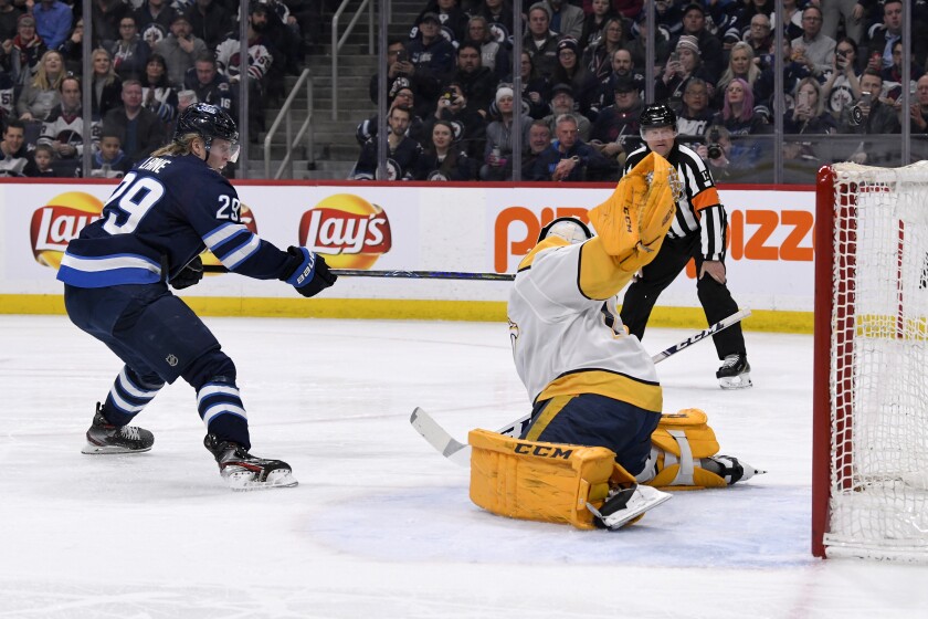 Nashville Predators goaltender Juuse Saros (74) makes a save on a penalty shot Winnipeg Jets' Patrik Laine (29) during the second period of an NHL hockey game Tuesday, Feb. 4, 2020, in Winnipeg, Manitoba. (Fred Greenslade/The Canadian Press via AP)