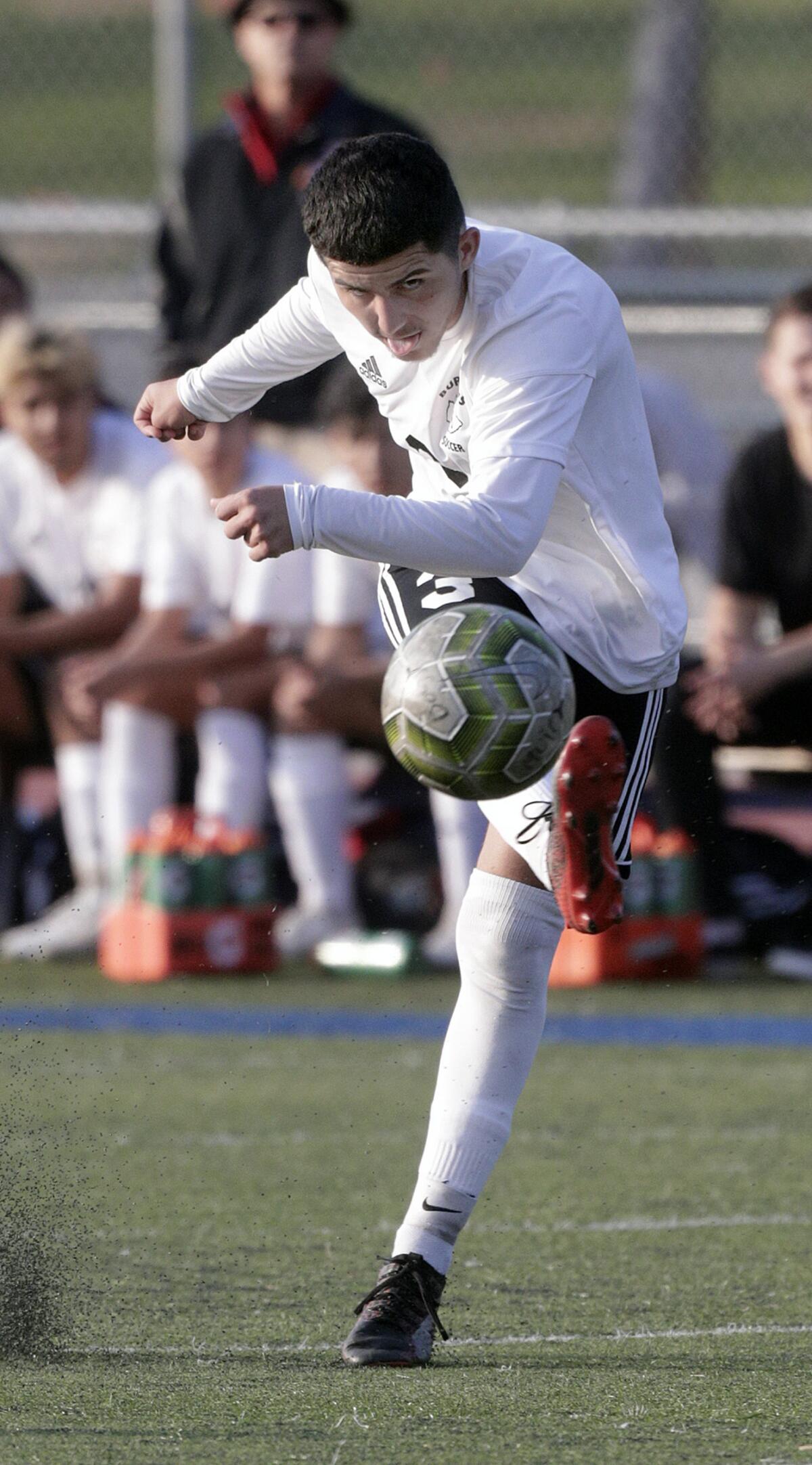 Burroughs' Manny Gonzalez takes a shot on the Muir goal in a Pacific League boys' soccer game at Muir High School in Pasadena on Tuesday, January 14, 2020.