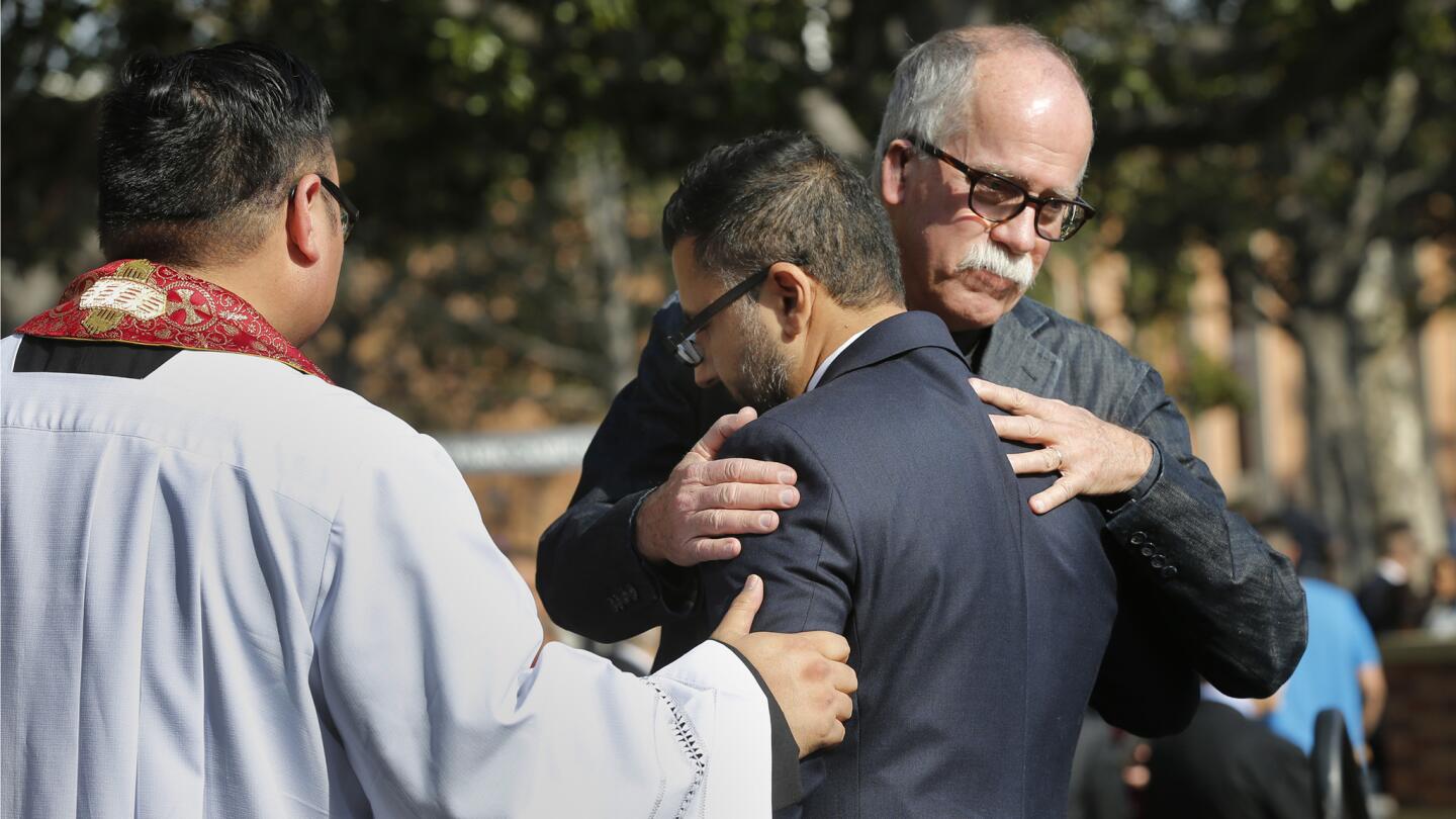 Father Richard Sunwoo of Caruso Catholic Center, left; Varun Soni, dean of religious life at USC; and the Rev. James Burklo, associate dean of religious life embrace.