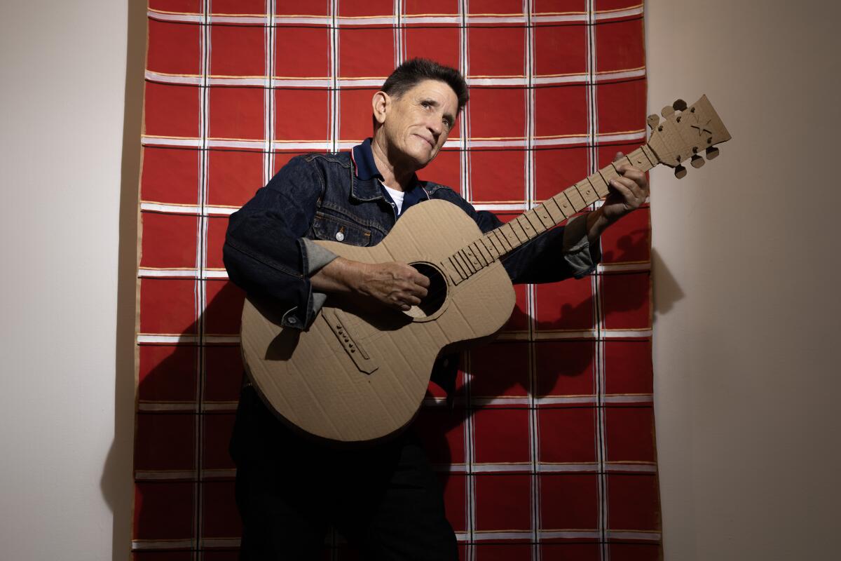 Phranc holds a life-size cardboard guitar at Craig Krull Gallery in Santa Monica.
