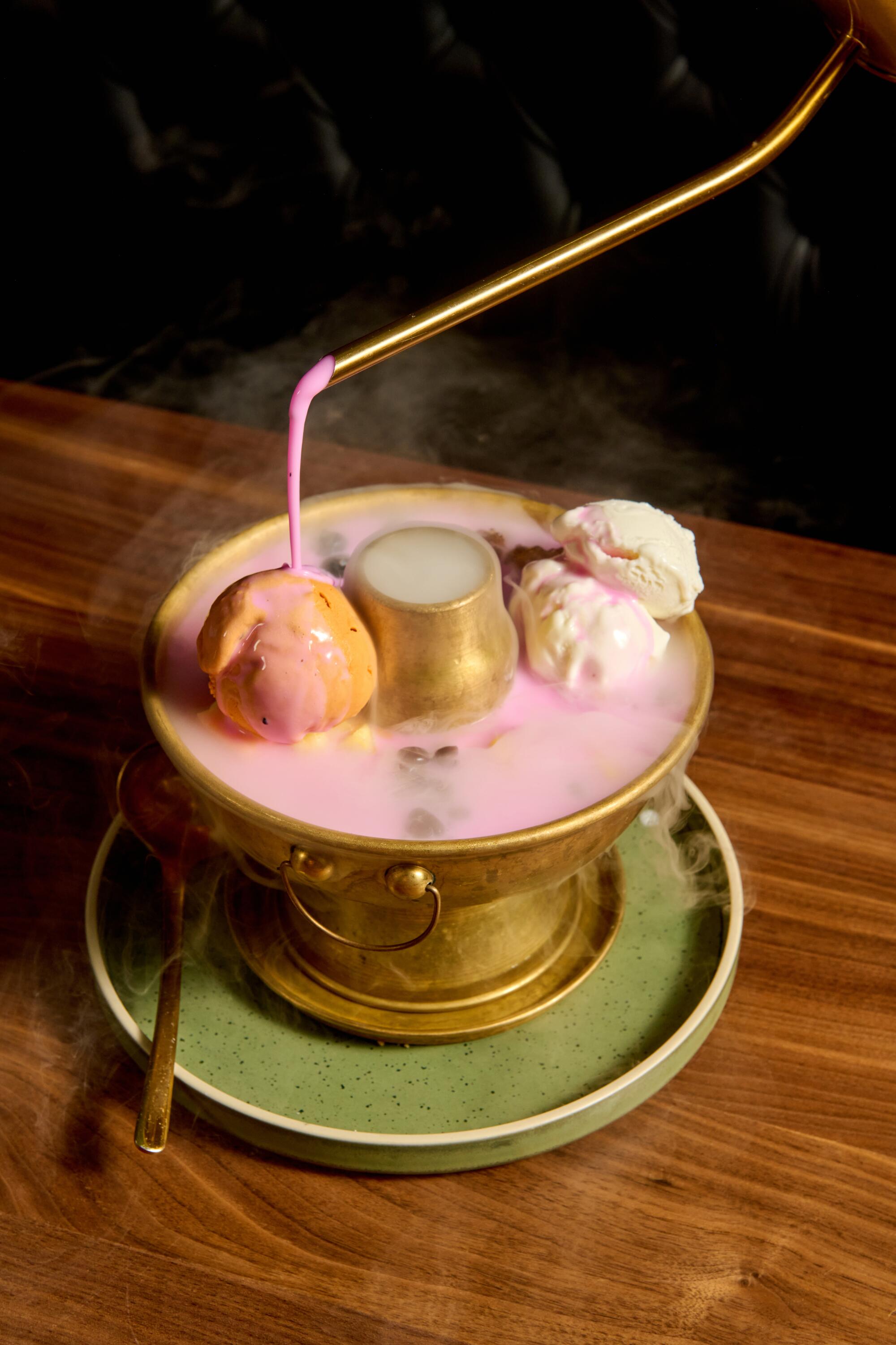 A waiter pours pink coconut cream over the Pink Mekong dessert.