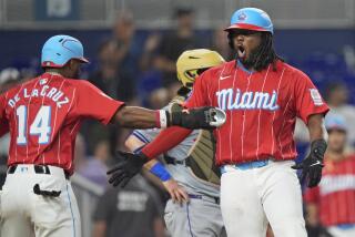 Josh Bell, de los Marlins de Miami, festeja con el dominicano Bryan de la Cruz tras empujarlo con un jonrón en el juego del sábado 18 de mayo de 2024 ante los Mets de Nueva York (AP Foto/Wilfredo Lee)