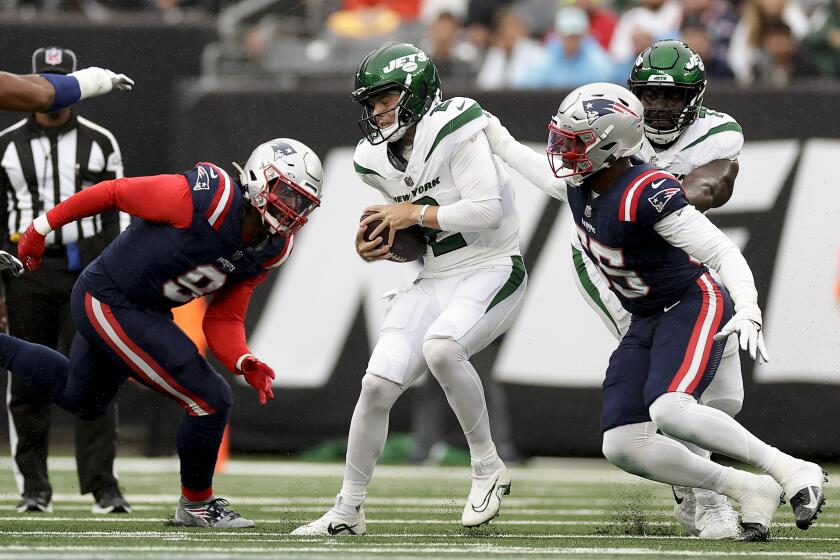 New York Jets quarterback Zach Wilson (2) is sacked by New England Patriots linebacker Josh Uche (55) and linebacker Matthew Judon (9) during the first quarter of an NFL football game, Sunday, Sept. 24, 2023, in East Rutherford, N.J. (AP Photo/Adam Hunger)