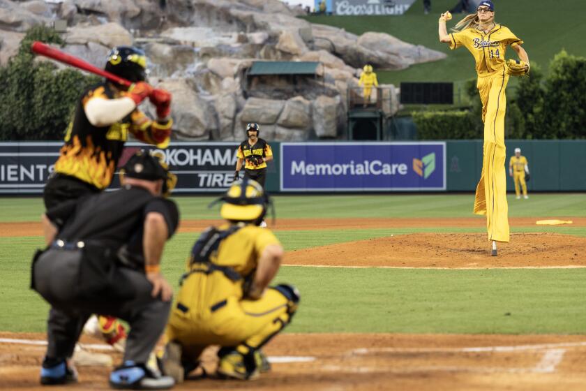 Anaheim, CA - May 30: The Savannah Bananas' Dakota Albritton throws a pitch on stilts as the Savannah Bananas take on the Firefighters at Angel Stadium on Friday, May 30, 2025 in Anaheim, CA. (Luke Johnson / Los Angeles Times)