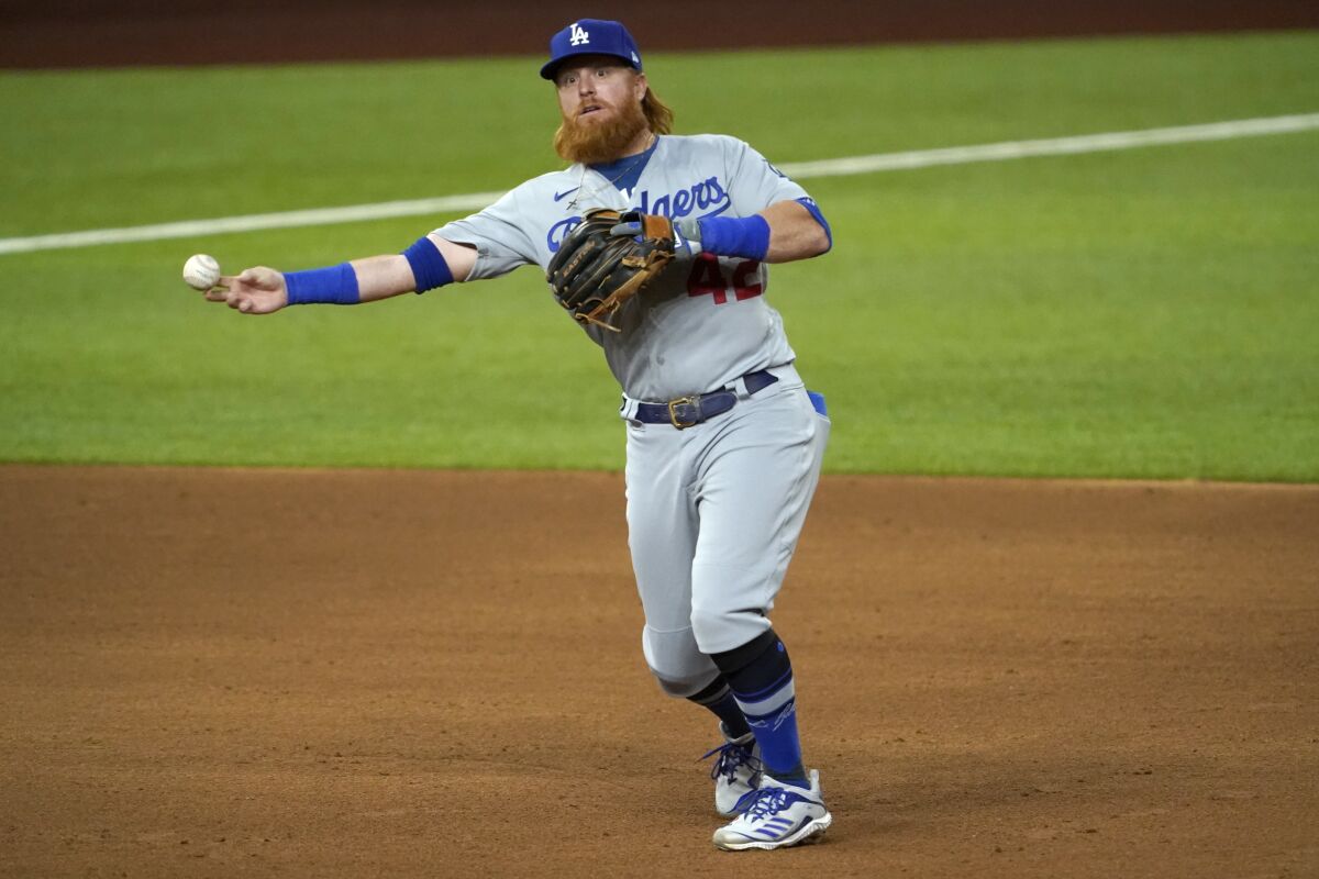 Los Angeles Dodgers third baseman Justin Turner throws to first to complete the ground out by Texas Rangers' Nick Solak in the sixth inning of a baseball game in Arlington, Texas, Friday, Aug. 28, 2020. (AP Photo/Tony Gutierrez)