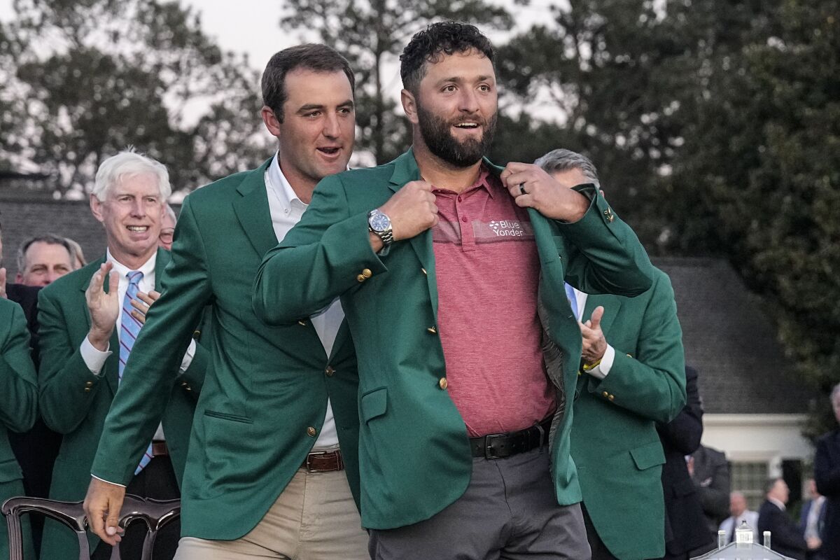 Scottie Scheffler met la veste verte sur Jon Rahm après la victoire de l'Espagnol au Masters.