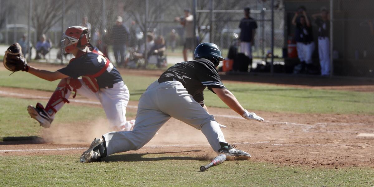 Costa Mesa High's Kyle Anderson dives for home plate during the third inning of an Orange Coast League game against Calvary Chapel at TeWinkle Park on Wednesday.