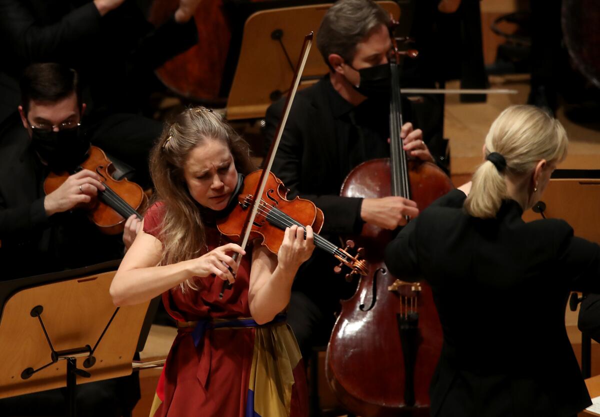 Violinist Leila Josefowicz plays with members of the L.A. Phil seated behind her.