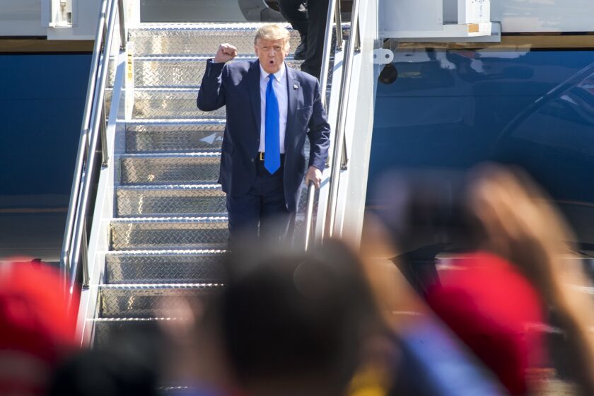 SANTA ANA, CA - OCTOBER 18: President Donald Trump greets cheering supporters as he arrives on Air Force One at John Wayne Airport on Sunday, Oct. 18, 2020 in Santa Ana, where he will be attending a fundraiser at the home of Palmer Luckey on Lido Island in Newport Beach. (Allen J. Schaben / Los Angeles Times)