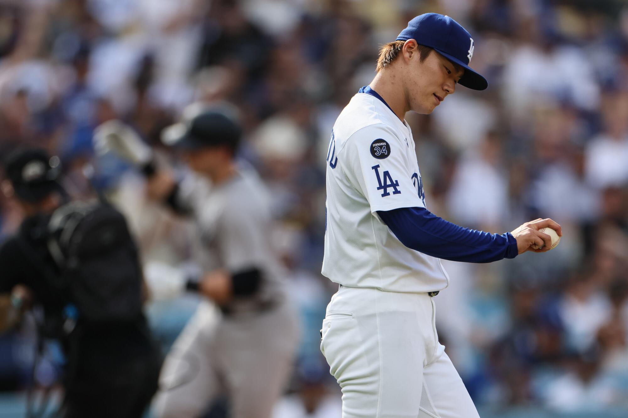Dodgers pitcher Yoshinobu Yamamoto walks back to the mound after giving up a home run.