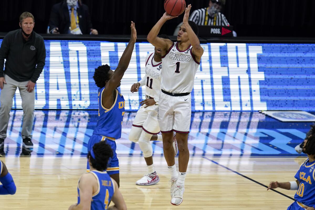 Gonzaga guard Jalen Suggs (1) shoots over UCLA guard David Singleton (34) to win the game during overtime in a men's Final Four NCAA college basketball tournament semifinal game, Saturday, April 3, 2021, at Lucas Oil Stadium in Indianapolis. Gonzaga won 93-90. (AP Photo/Michael Conroy)