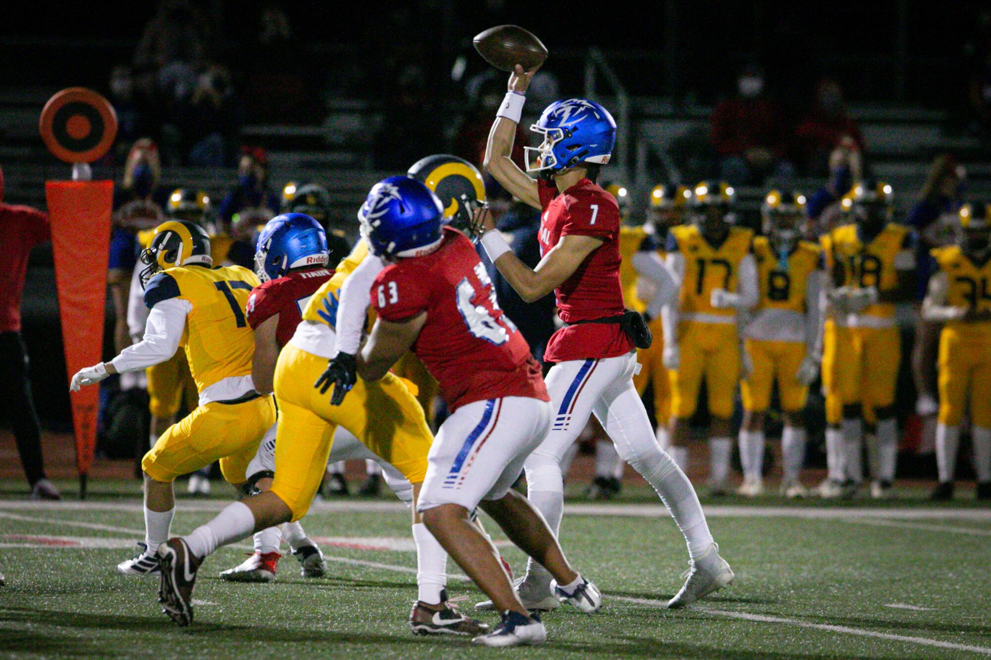 Los Alamitos quarterback Malachi Nelson passes while surrounded by Millikan players.