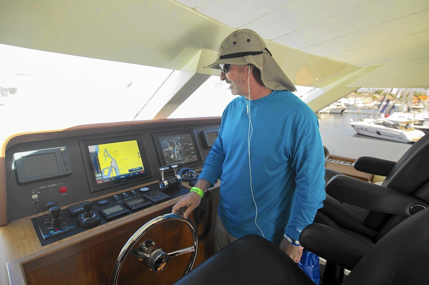 Scott Palmer, from Redondo Beach, checks out the view from the captain's chair of a 2015 Johnson Sky-Lounge 65' Enclosed Bridge Motoryacht during the the 37th annual Lido Boat Show in Newport Beach on Friday.