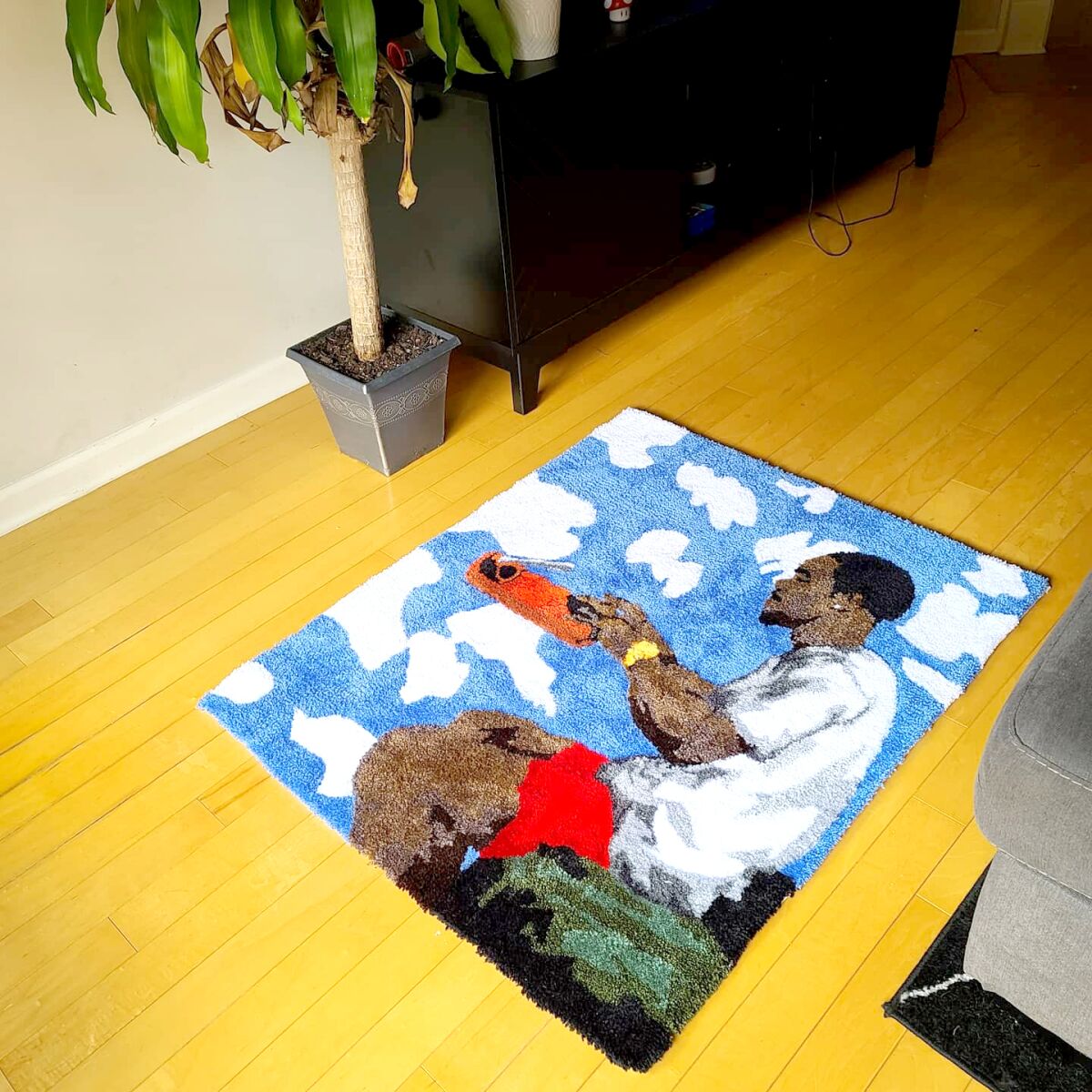 A rug depicts musician Frank Ocean seated and typing on a floating typewriter.