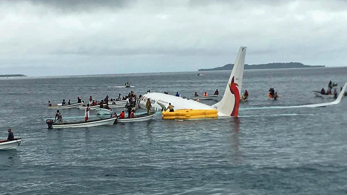 Locals help rescue passengers from the crashed Air Niugini aircraft on the remote island of Weno in Micronesia.