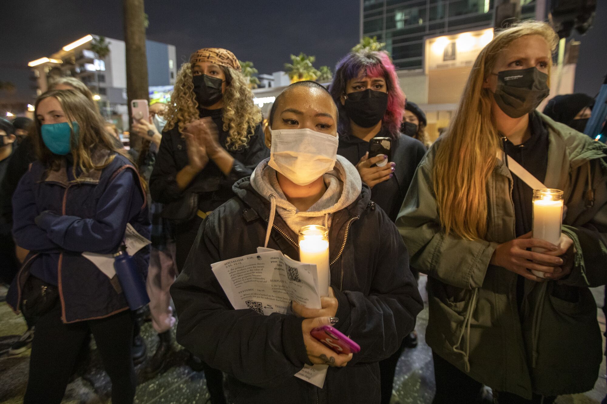 Chloe Tang, middle, participates in an anti-police brutality vigil near Sunset and Vine in Hollywood.