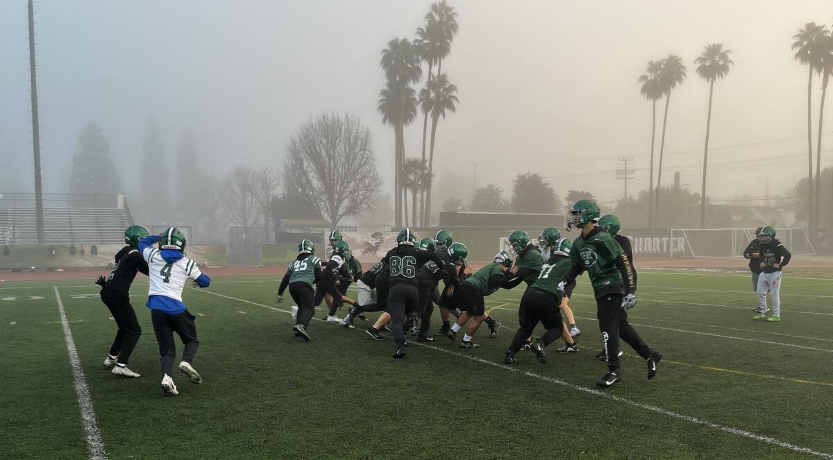 Dijon Stanley takes a handoff during Granada Hills' football practice Monday morning.