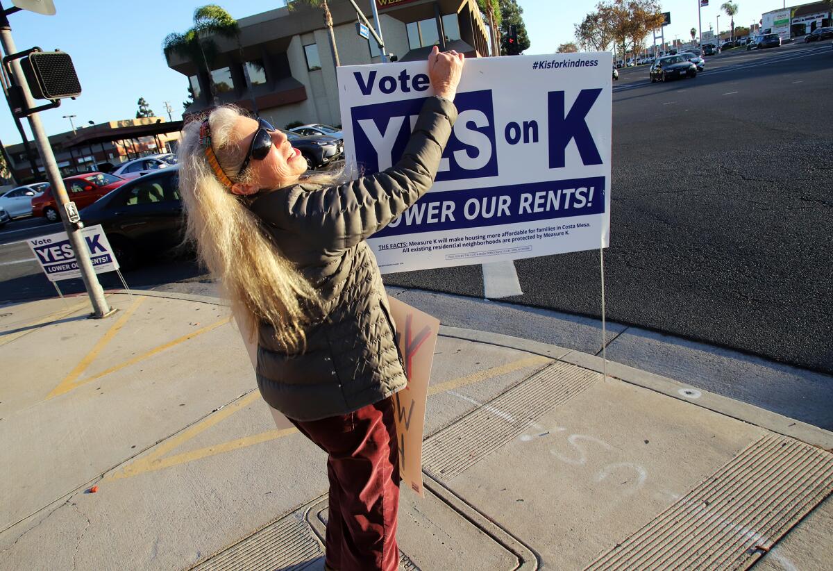 Costa Mesan Kathy Esfahani rallies Thursday in support of Measure K at the intersection of Harbor Boulevard and Baker Street.