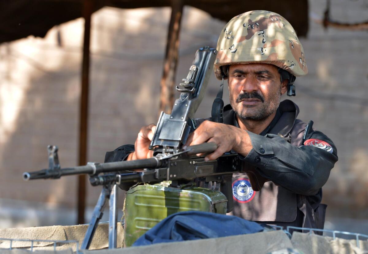 A Pakistani policeman loads his gun at a security check point in Peshawar in November.