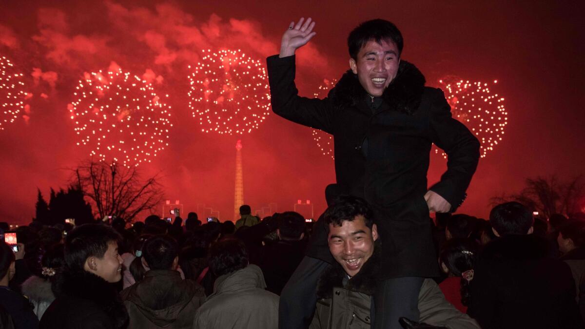 A man poses for a photo as people watch a fireworks display near the Taedong river, on the occasion of the 75th anniversary of the birth of Kim Jong Il, in central Pyongyang, North Korea, on Feb. 16, 2017.