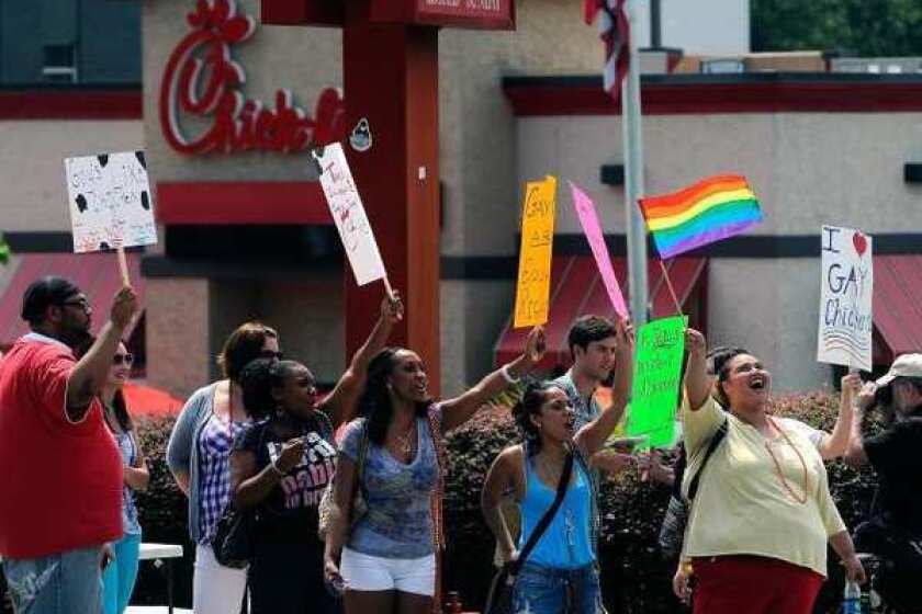 Gay rights groups and others protest and hold a "kiss-in" outside the Decatur, Ga., Chick-fil-A restaurant Friday.