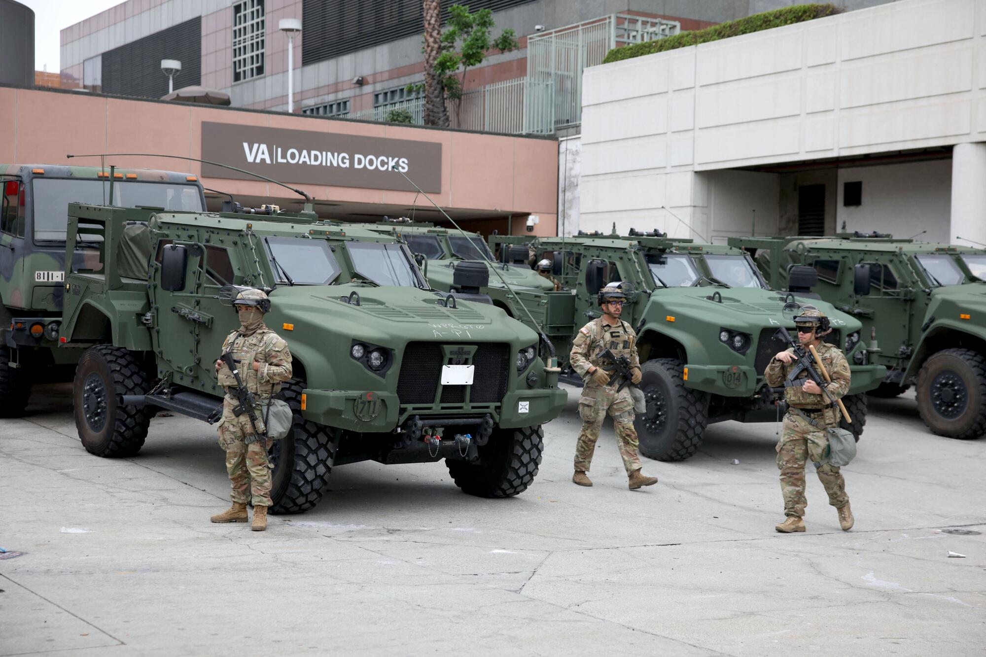 Troops and military vehicles in a lot.