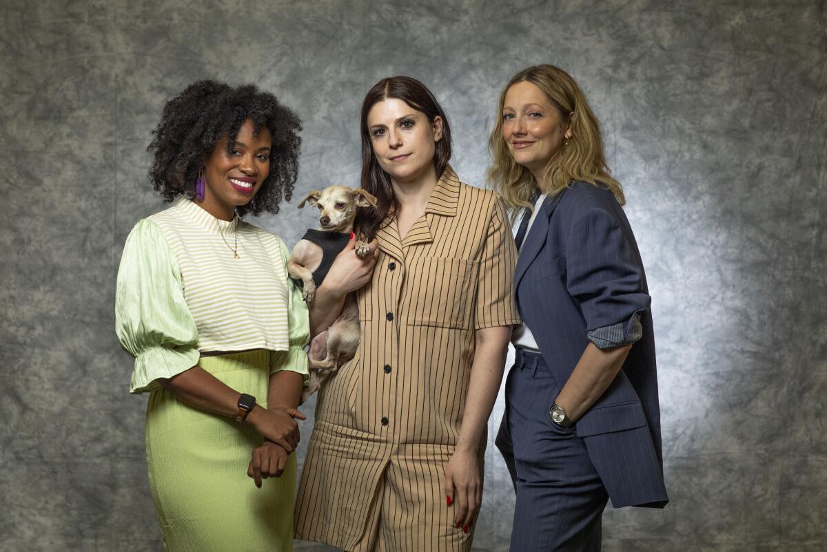 Three women posing with a dog