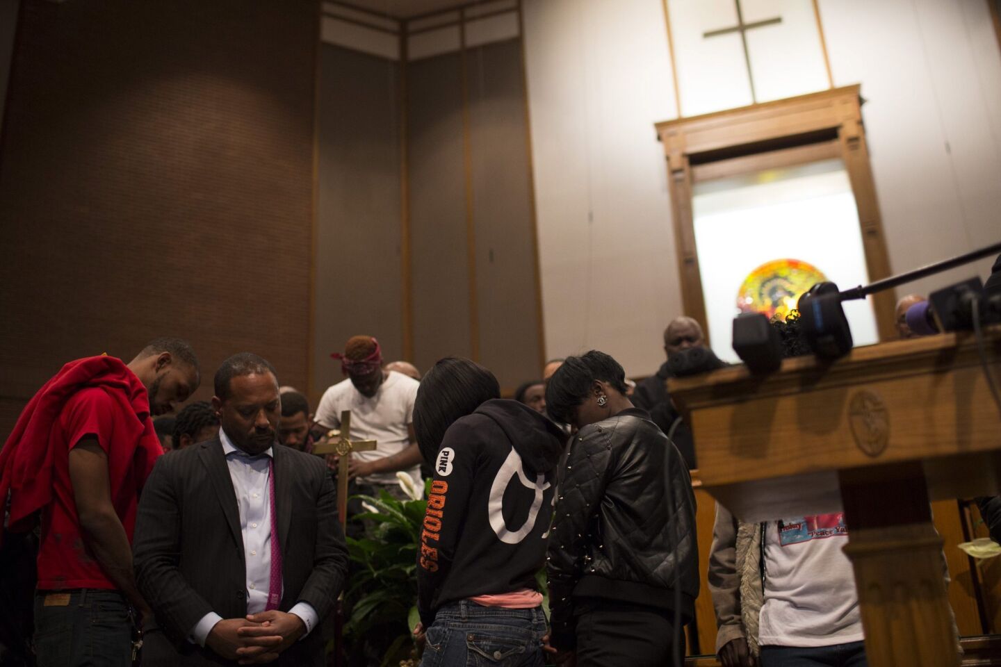The Family of Freddie Gray, who died after a fatal injury in police custody, pray inside a church after a news conference in Baltimore on Monday.