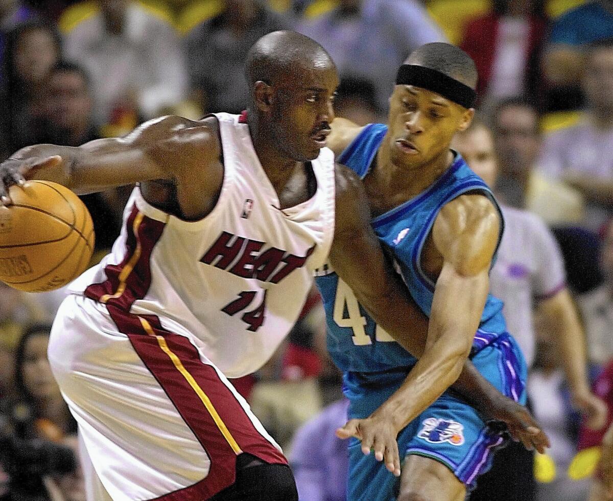 Miami's Anthony Mason, left, drives against Charlotte's P.J. Brown in an NBA game in 2001. Mason, a rugged power forward who was a defensive force throughout his career, has died at the age of 48.