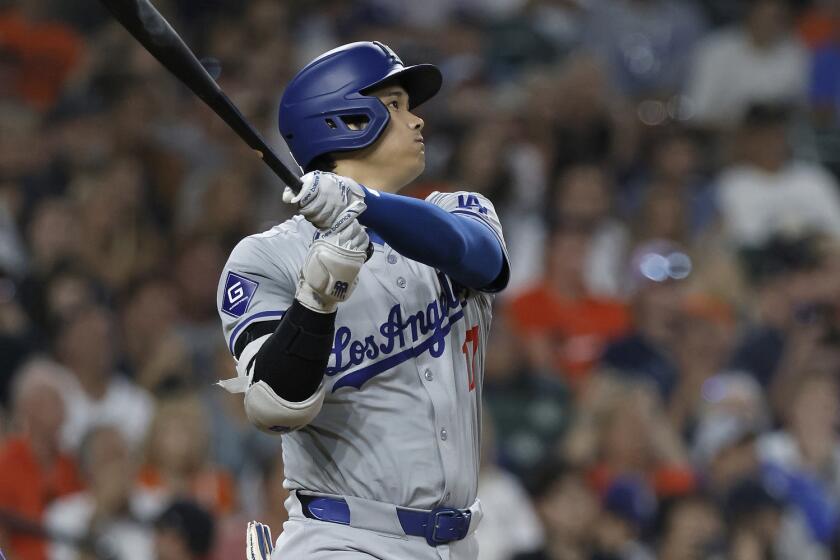 Los Angeles Dodgers' Shohei Ohtani hits a double that bounced over the center field.
