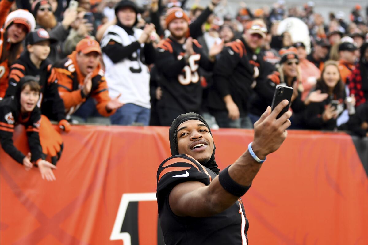 FILE - Cincinnati Bengals wide receiver Ja'Marr Chase (1) takes a video with fans in the background after the team's win over the Baltimore Ravens in an NFL football game Dec. 26, 2021, in Cincinnati. The Bengals rebounded from three consecutive last-place finishes in the AFC North to reach the Super Bowl. They play the Los Angeles Rams in SoFi Stadium on Feb. 13. (AP Photo/Emilee Chinn, File)