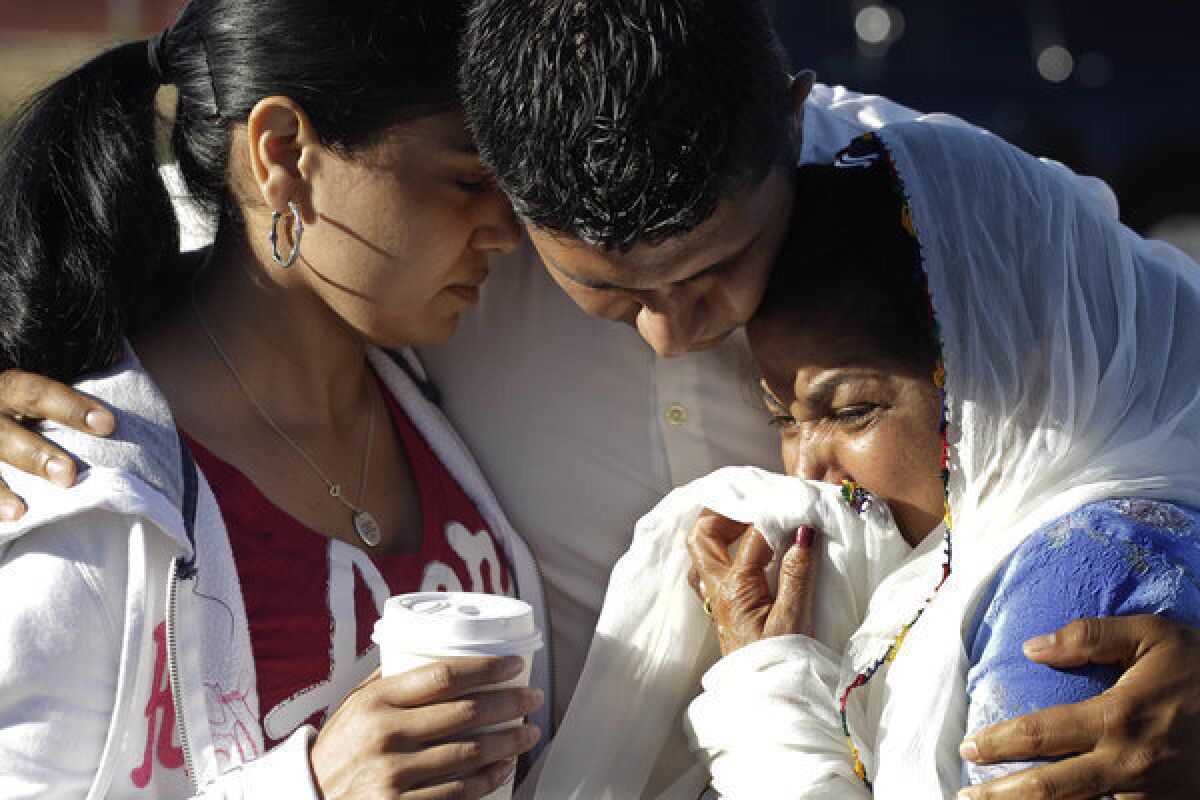 Amardeep Kaleka, son of the president of the Sikh Temple of Wisconsin, center, comforts members of the temple in Oak Creek, Wis. in August 2012. Twelve months ago, a white supremacist walked into a the temple and opened fire on worshipers he didn't know, killing six and devastating a Sikh community.
