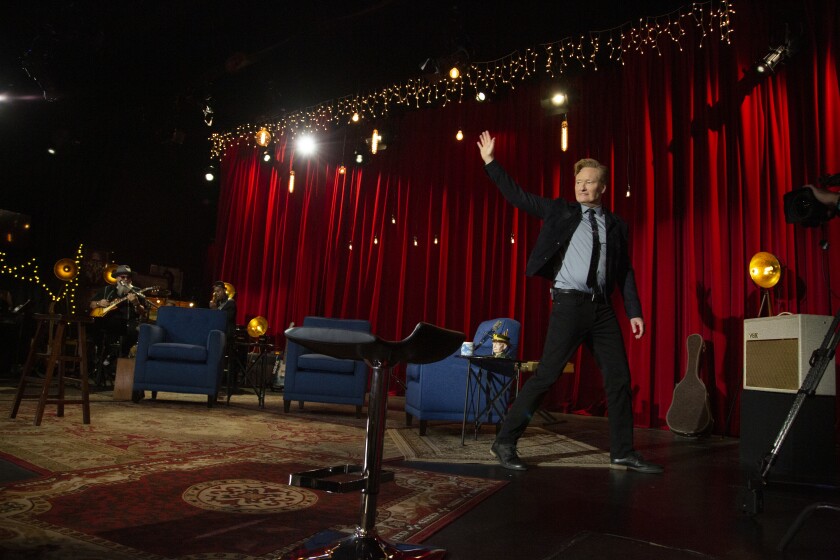 Conan O'Brien waves to the live audience in his last episode