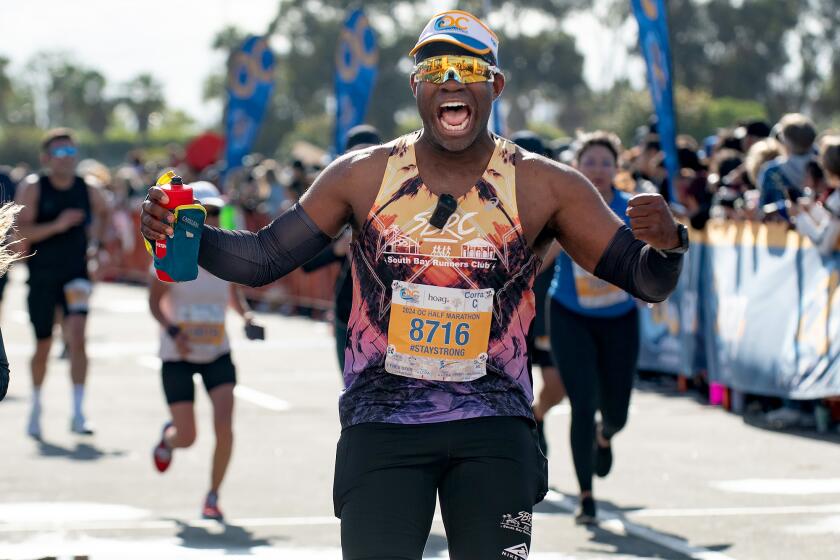 Maurice Washington pumps his fists as he approaches the finish line of the Orange County Half Marathon at the OC Fair & Event Center in Costa Mesa on Sunday, May 5. He had been diagnosed with a brain tumor in 2017, and had to relearn how to walk before joining a running club and eventually signing up for marathons.