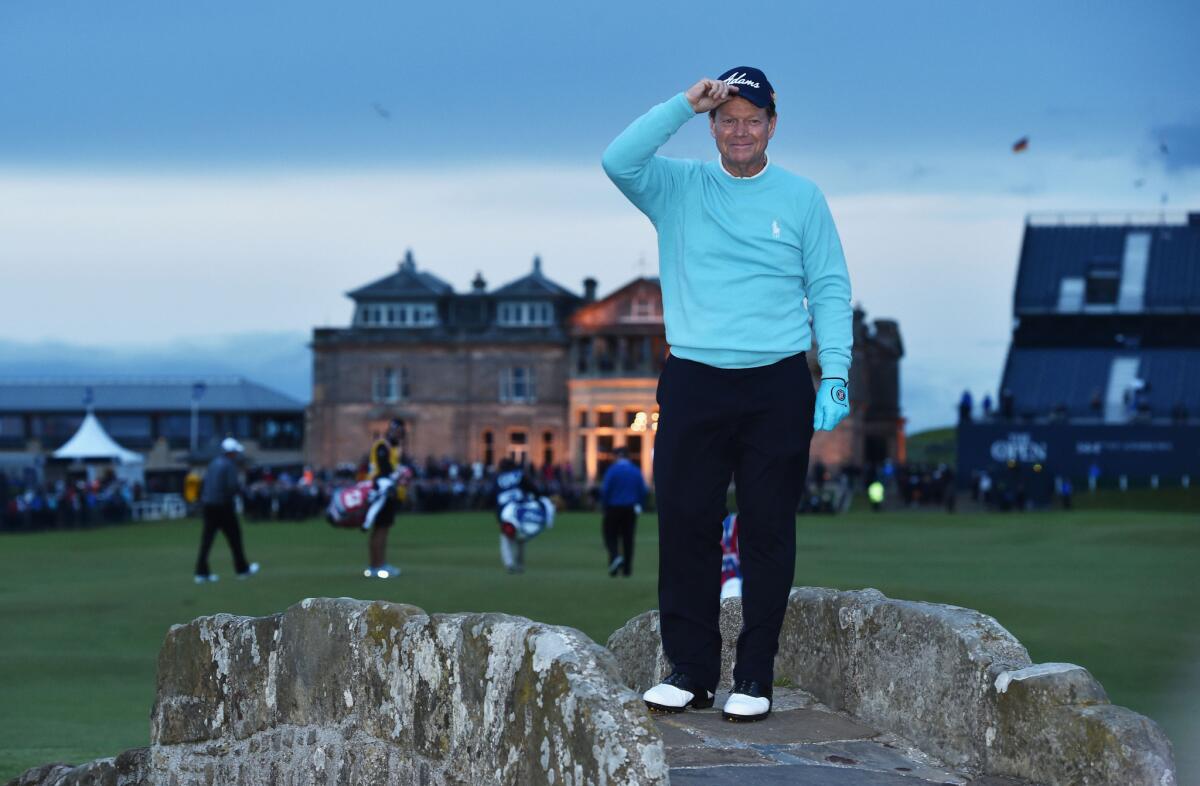 Tom Watson tips his cap to the crowd from Swilcan Bridge on Friday in honor of what is likely his final round of competitive golf in the British Open.