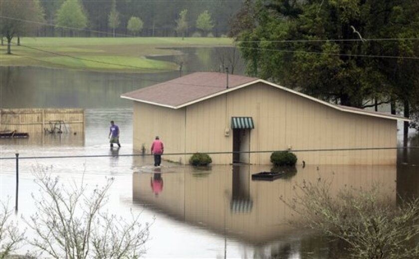 Matt Galloway, left, and golf course superintendent Vance Langham walk through receding floodwaters Wednesday, April 1, 2009 that inundated the River Oaks Golf Course in Geneva, Ala., this week. Officials say hundreds of homes have been flooded by heavy rains this week and more rain is expected to fall. (AP Photo/Dave Martin)