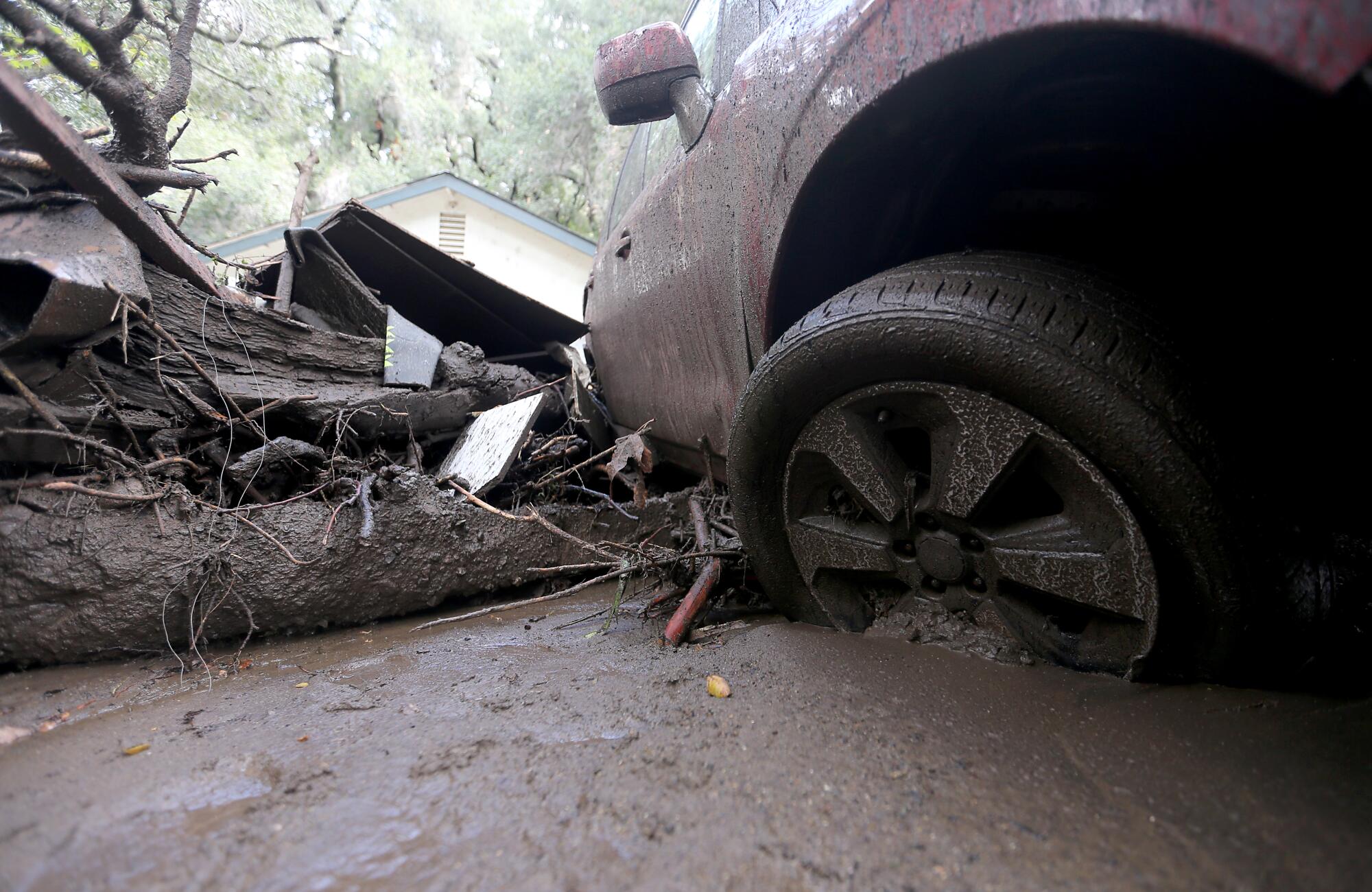 A car's wheel well is surrounded by mud