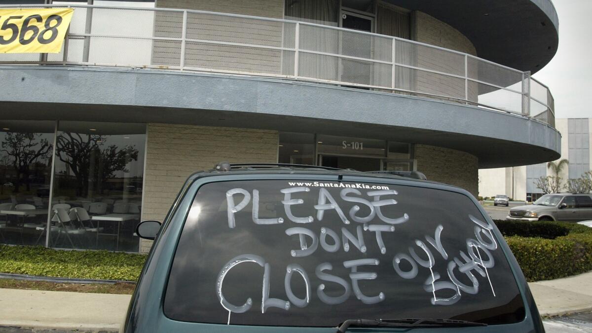 A van bearing a message sits in the parking lot in front of one of the buildings at Albor Charter School in Santa Ana in April 2005.