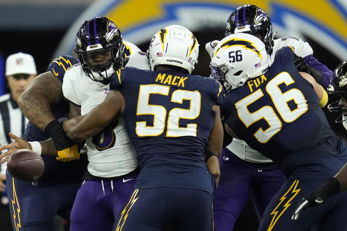 Ravens quarterback Lamar Jackson (8), fumbles as he is sacked by Chargers linebacker Khalil Mack (52).