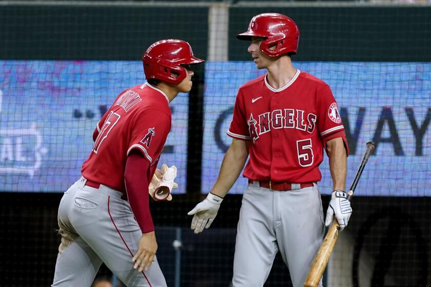 Los Angeles Angels' Shohei Ohtani and Matt Duffy (5) celebrate after Ohtani scored on a Taylor Ward double in the sixth inning of a baseball game against the Texas Rangers in Arlington, Texas, Tuesday, Sept. 20, 2022. (AP Photo/Tony Gutierrez)