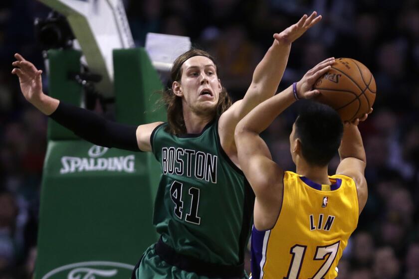 Lakers point guard Jeremy Lin has his shot challenged by Celtics center Kelly Olynyk in the first half.