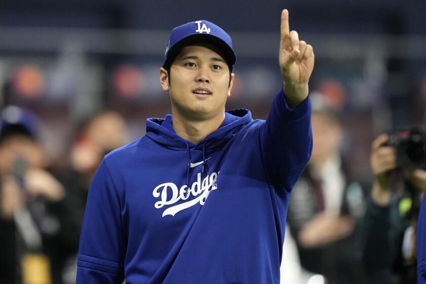 Los Angeles Dodgers designated hitter Shohei Ohtani gestures as he warms up.