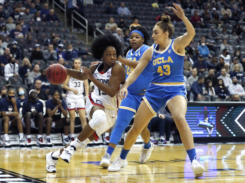 Connecticut guard Christyn Williams, left, drives against UCLA forward Izzy Anstey during a game on Dec. 11.