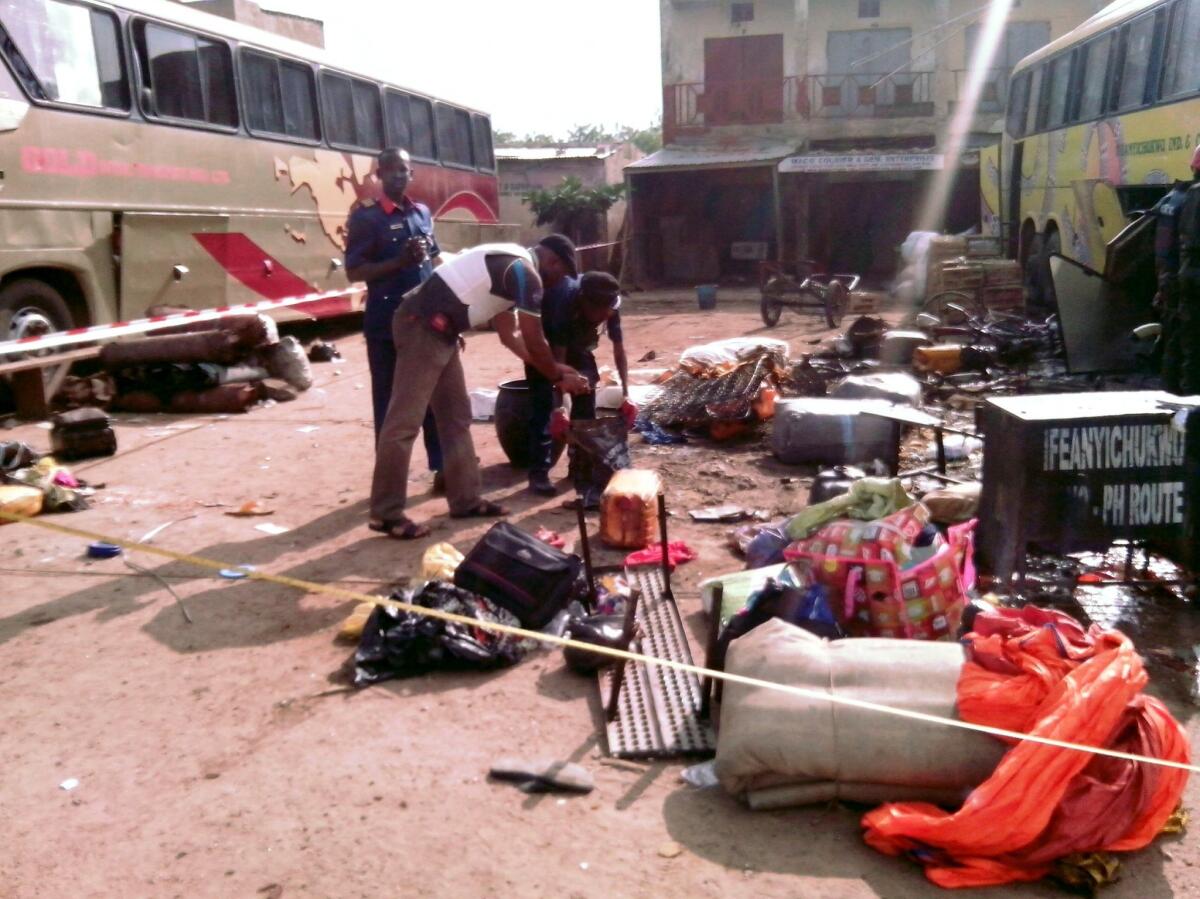 Security officers examine abandoned items at the scene of a blast in the northern Nigerian city of Kano on July 24. The city has recently been the site of several suicide bombings involving young women.