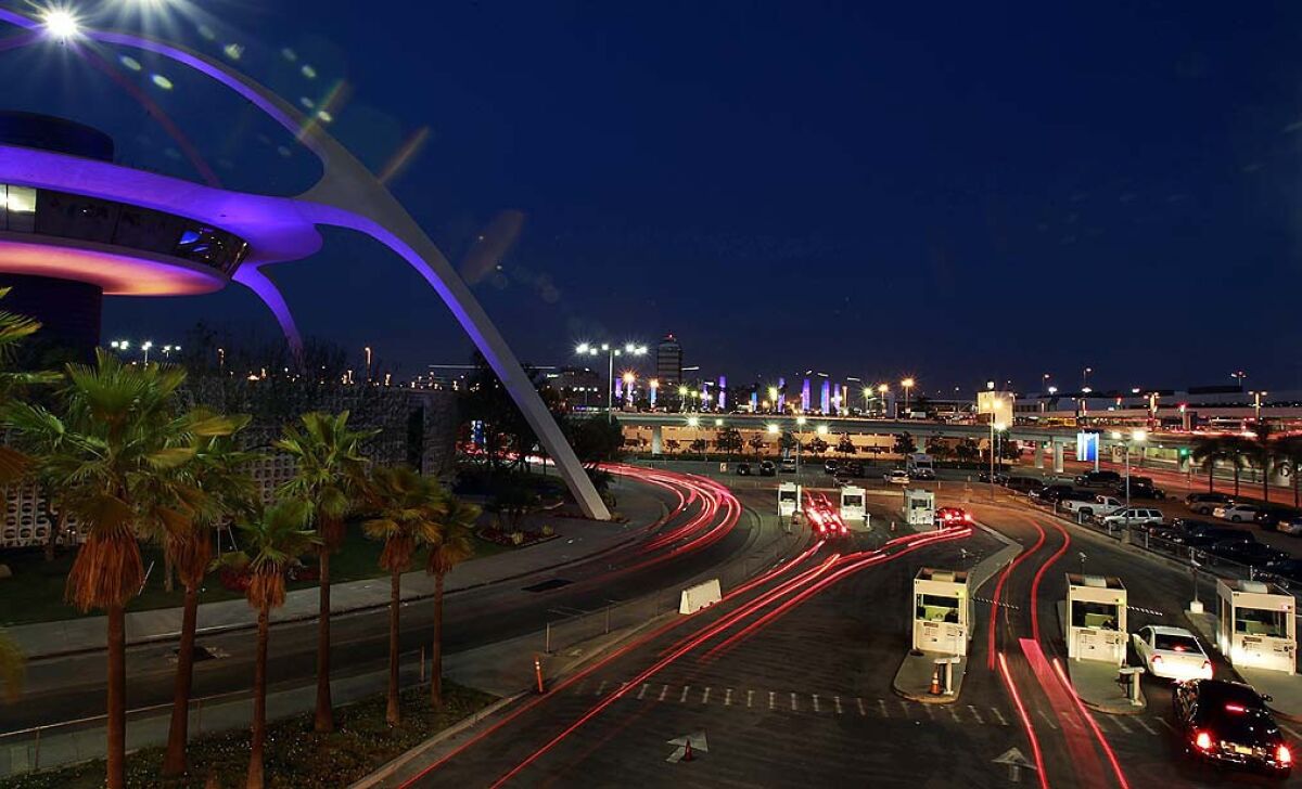 Traffic moves past the Encounters restaurant at LAX. More than a year after airport police began cracking down on ride-hailing services picking up passengers in the terminal area, Los Angeles city officials are pushing regulators to legalize Uber and Lyft.